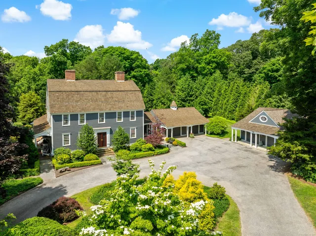 a front view of a house with a yard and green space