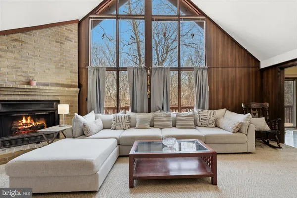 a living room with furniture a fireplace and kitchen view