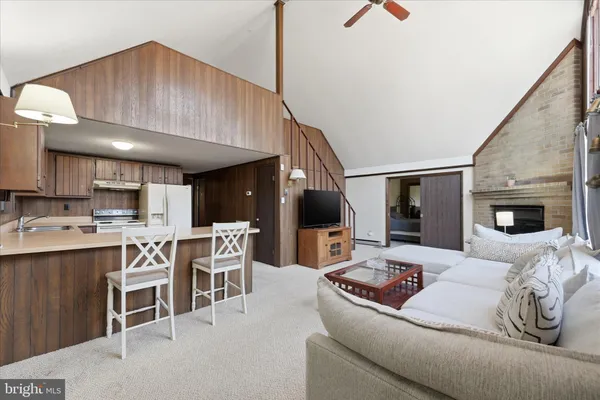 a living room with furniture a fireplace and kitchen view