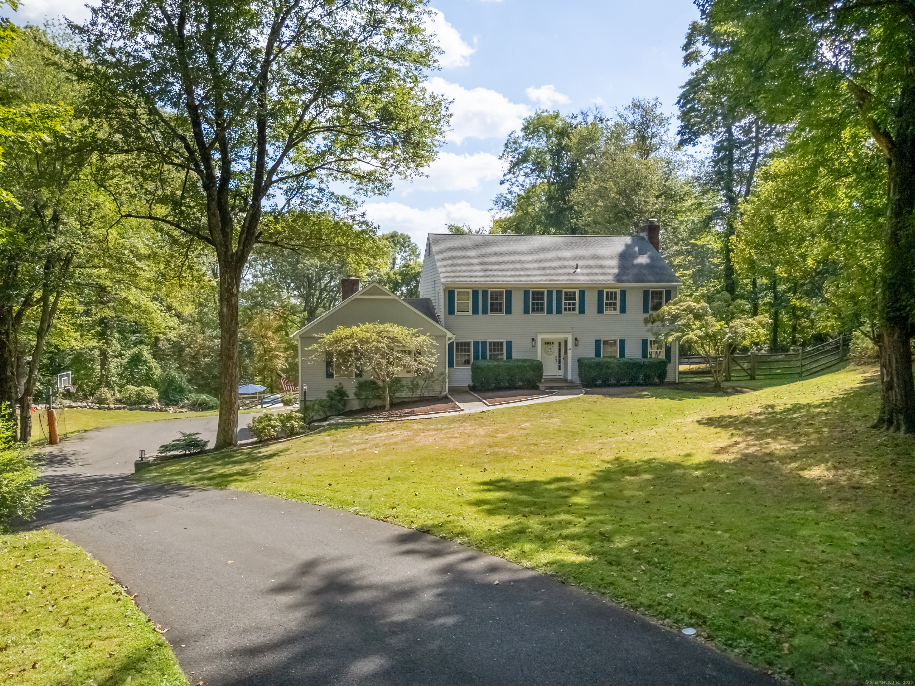 a view of a house with pool and trees in the background