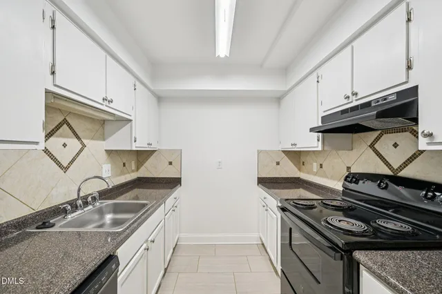a kitchen with granite countertop a sink stove and cabinets