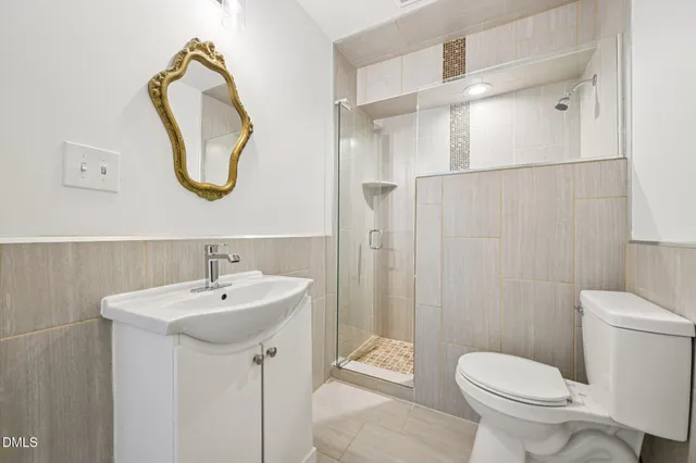 a bathroom with a sink a toilet and a mirror