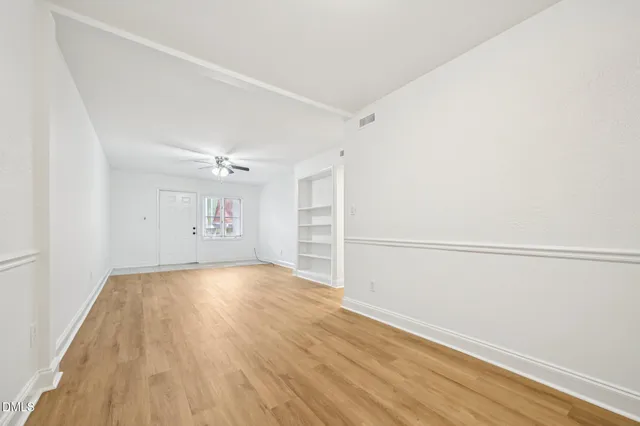 a view of a room with wooden floor and window