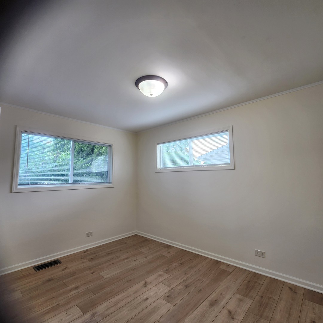 208 Albert Terrace Wheeling, IL 60090 - Photo 11 of 15 an empty room with wooden floor and windows