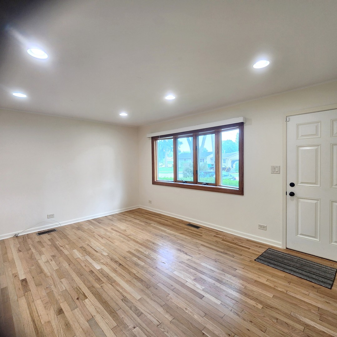 208 Albert Terrace Wheeling, IL 60090 - Photo 3 of 15 an empty room with wooden floor and windows