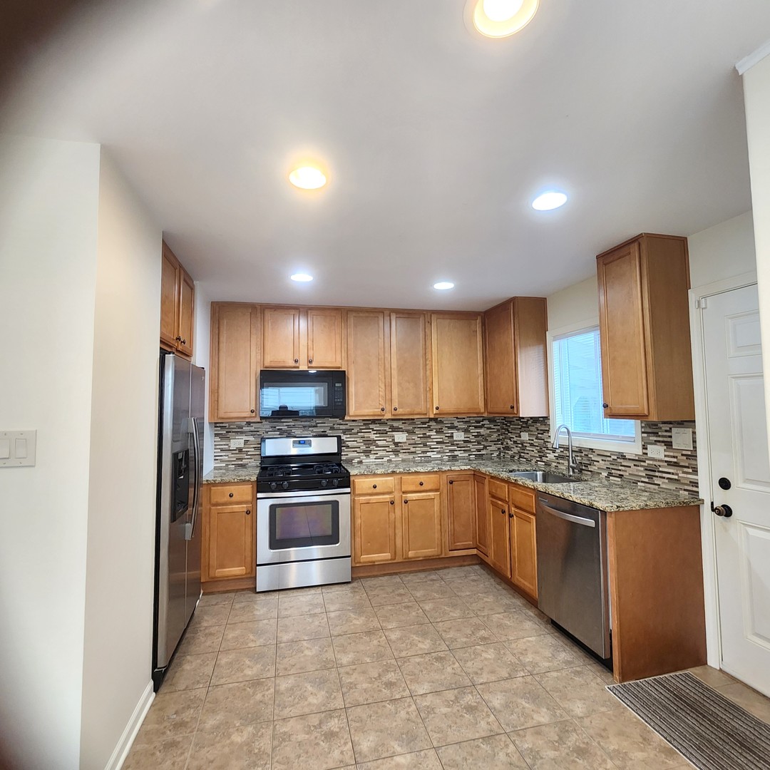208 Albert Terrace Wheeling, IL 60090 - Photo 7 of 15 a kitchen with stainless steel appliances granite countertop a stove and a sink