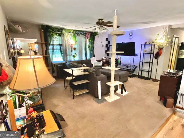 a living room with furniture a flat screen tv and a table