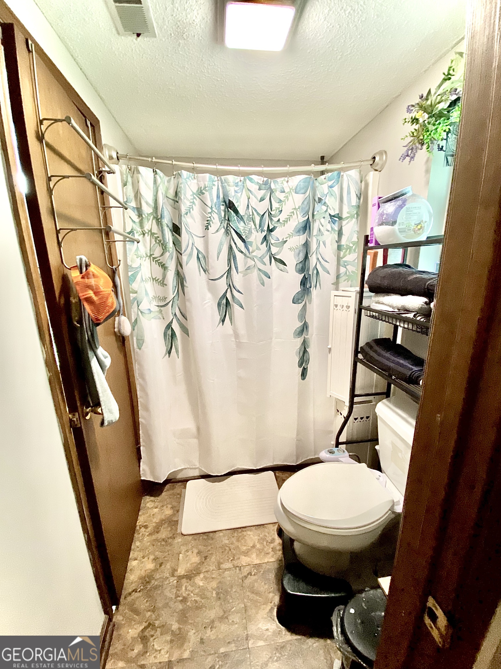 253 Stancil Drive Toccoa, GA 30577 - Photo 19 of 26 a white toilet sitting next to a shower curtain