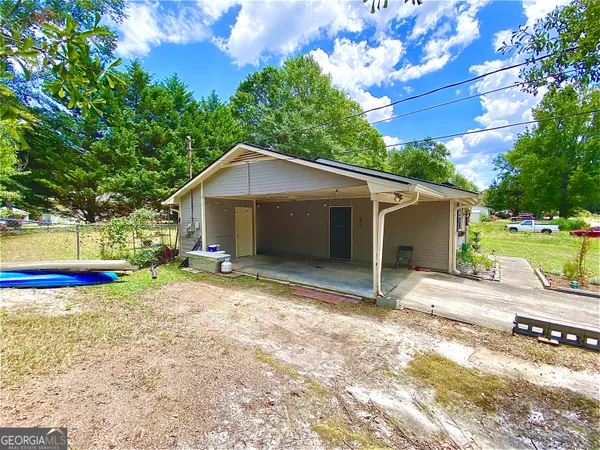 a view of a house with backyard and sitting area