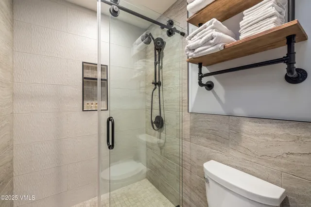 a bathroom with a toilet and a shower