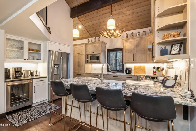 a kitchen with granite countertop a sink cabinets and stainless steel appliances