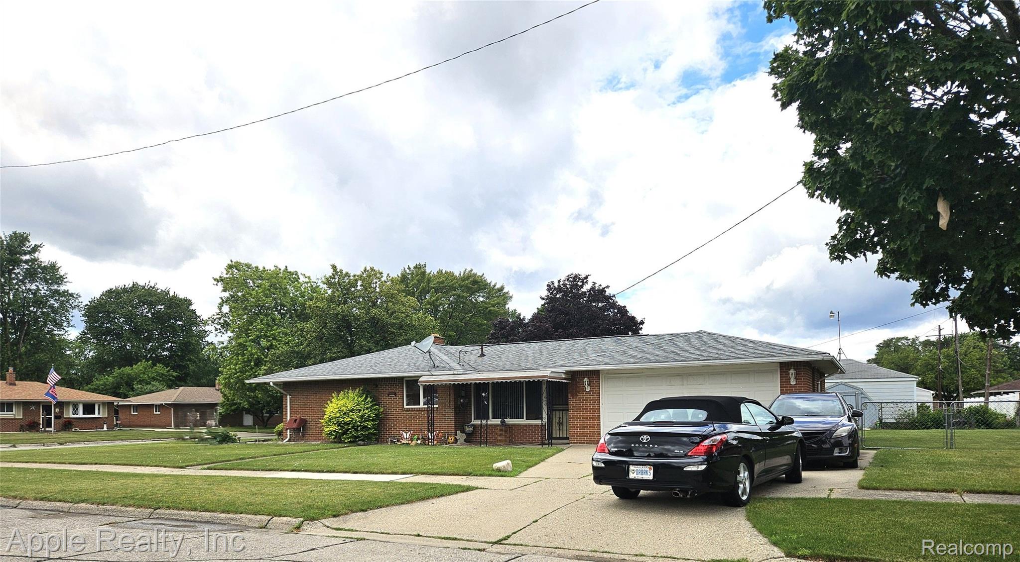 4851 Harrison Street Wayne, MI 48184 - Photo 2 of 8 Side View, Lovely Brick Ranch home featuring a two-car garage, fenced backyard, storage shed, concrete driveway, and mature landscaping