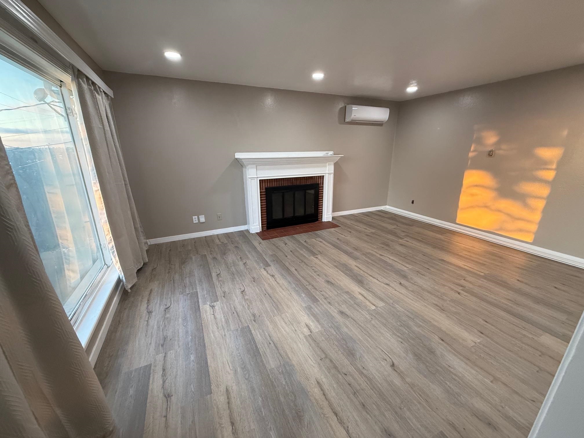 17028 Santa Fe Street Hayward, CA 94541 - Photo 18 of 54 an empty room with wooden floor and fireplace