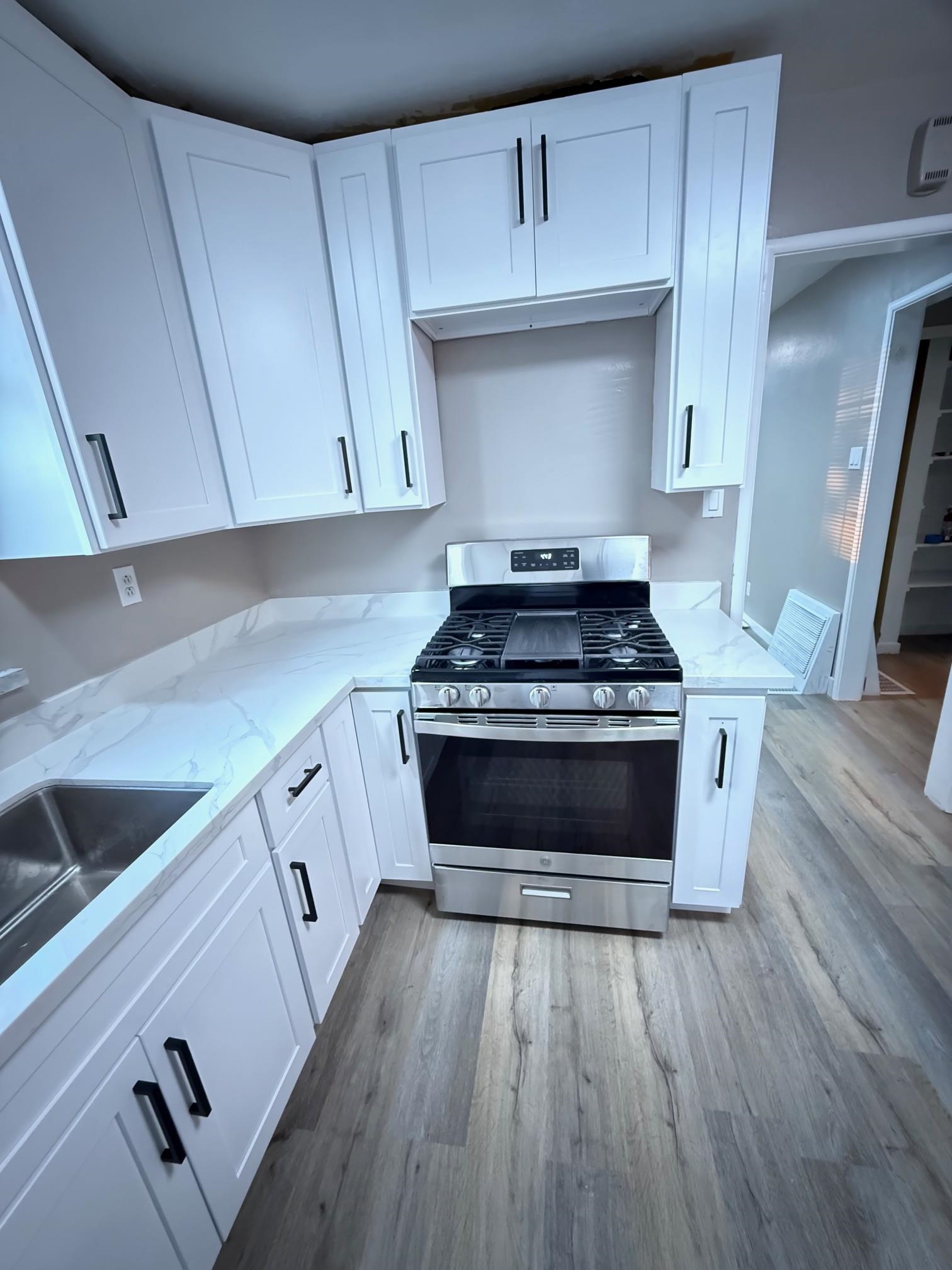 17028 Santa Fe Street Hayward, CA 94541 - Photo 24 of 54 a kitchen with a stove and white cabinets