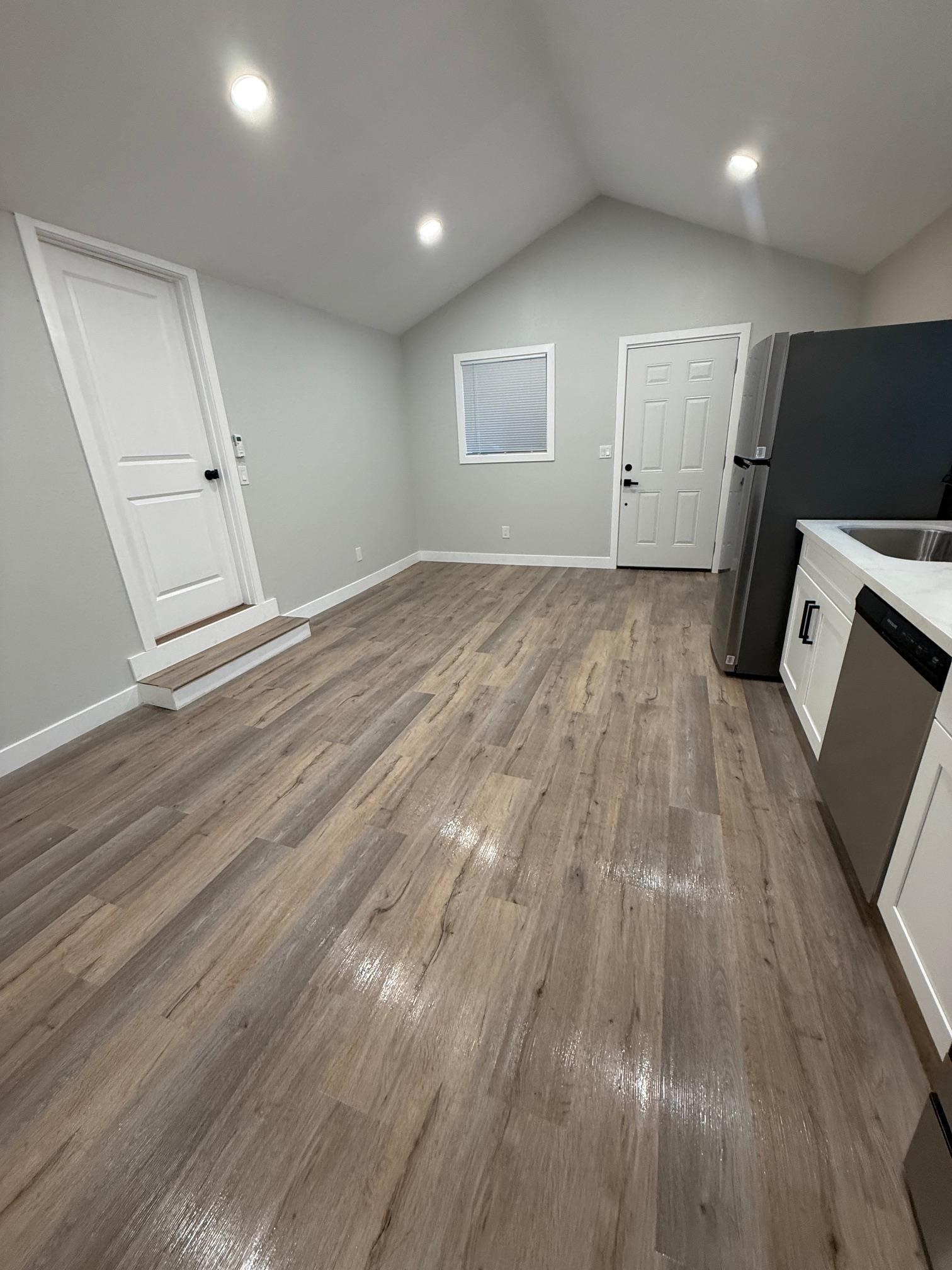 17028 Santa Fe Street Hayward, CA 94541 - Photo 35 of 54 an empty room with wooden floor and a fireplace