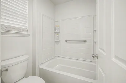 a white bath tub sitting next to a white toilet