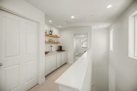 a kitchen with white cabinets and wooden floor