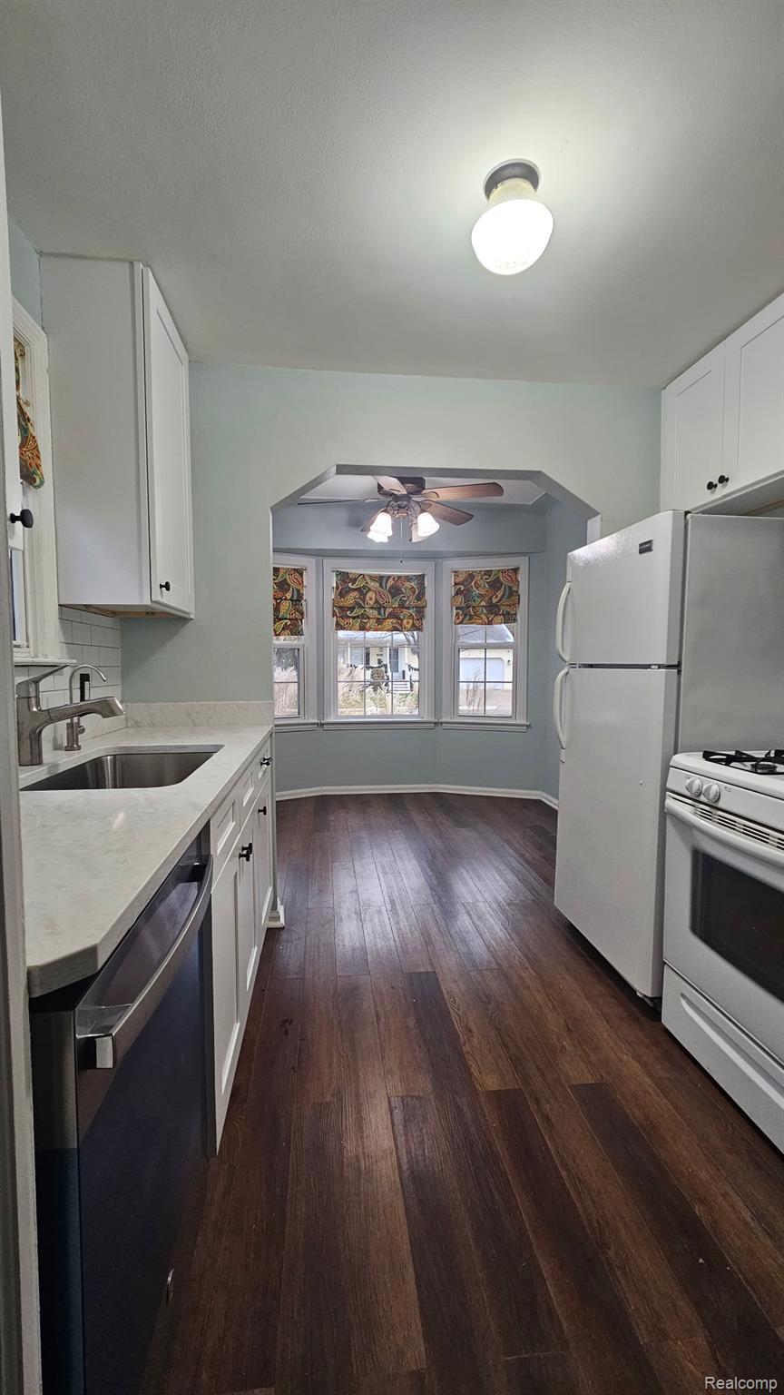 2259 Cambridge Road Berkley, MI 48072 - Photo 7 of 20 Kitchen featuring arched walkways, a ceiling fan, white cabinets, white appliances, and dark wood-style floors