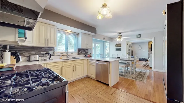 a kitchen with stainless steel appliances sink stove refrigerator and cabinets