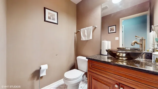 a bathroom with a granite countertop toilet and sink