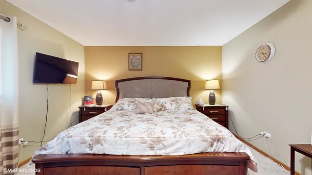 a bedroom with a bed and flat screen tv