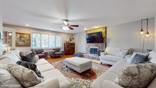 a living room with furniture a large window and a flat screen tv