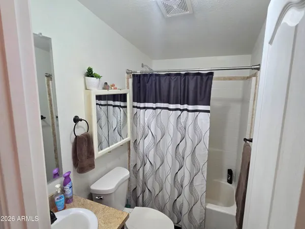 a bathroom with a toilet and a shower curtain