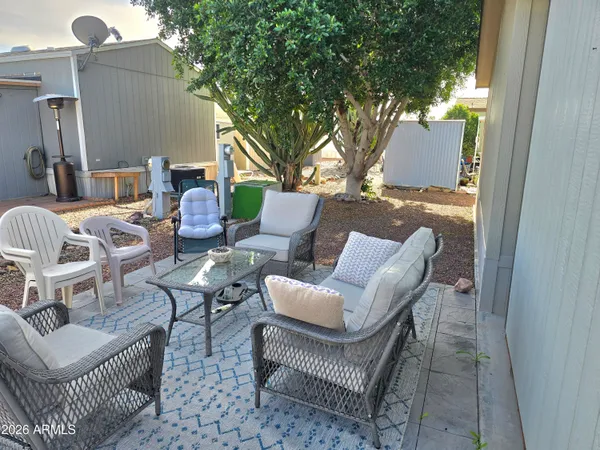 a view of a patio with couches and a table and chairs with wooden fence