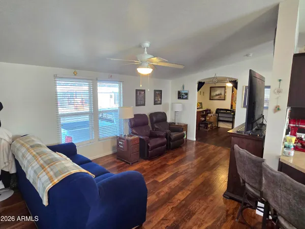 a living room with furniture a ceiling fan and a window