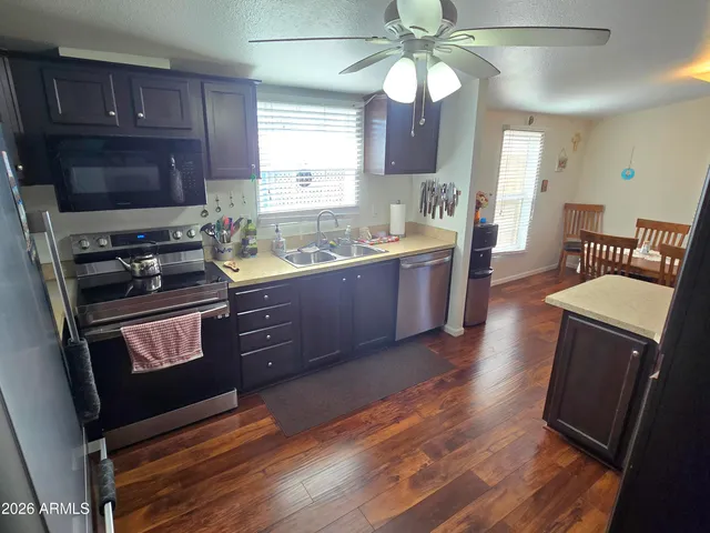 a kitchen with a stove a sink and wooden floor