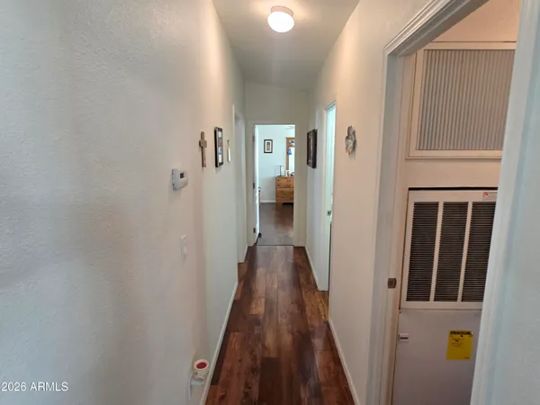 a view of a hallway with wooden floor and staircase