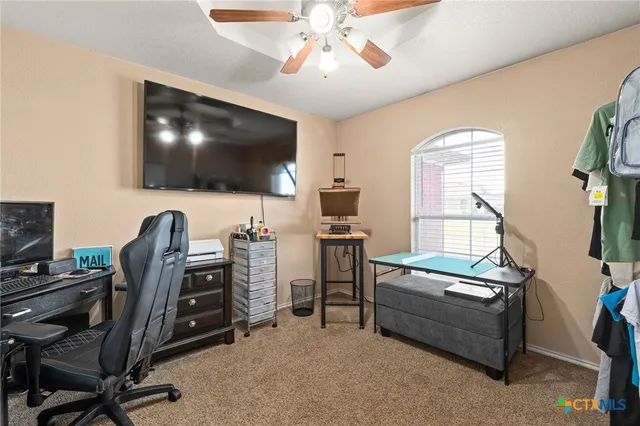 a view of a livingroom with workspace and a window