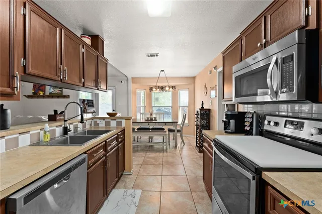 a kitchen with a sink a stove and cabinets