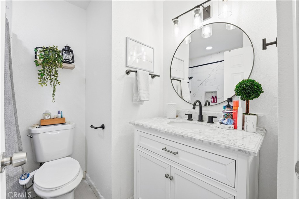 11908 Fallingleaf Circle Garden Grove, CA 92840 - Photo 11 of 30 a bathroom with a toilet sink and mirror