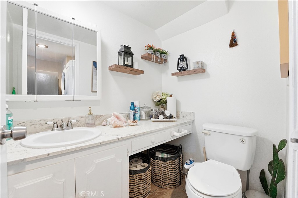 11908 Fallingleaf Circle Garden Grove, CA 92840 - Photo 19 of 30 a bathroom with a sink a toilet a mirror and vanity