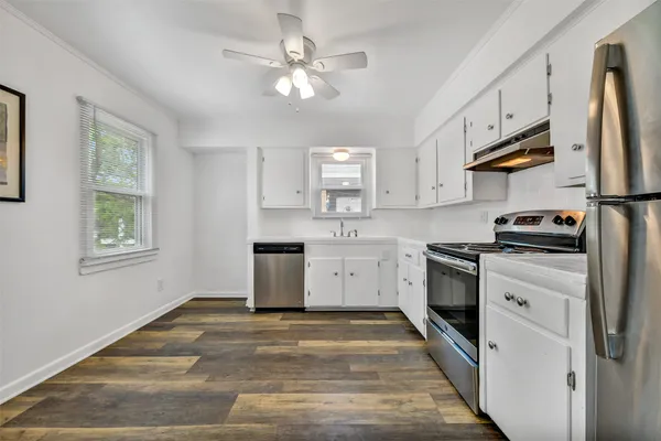 a kitchen with granite countertop a sink stainless steel appliances and cabinets