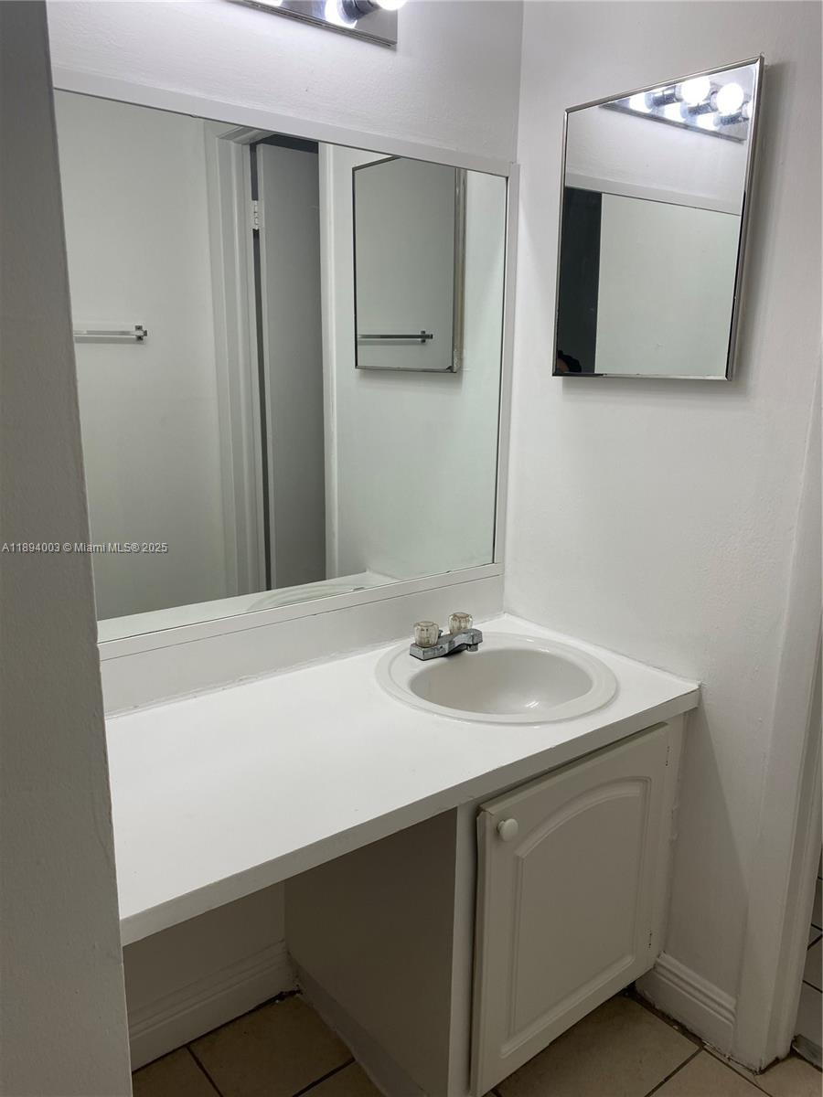 4453 Treehouse Lane, Unit C Tamarac, FL 33319 - Photo 15 of 21 a bathroom with a sink and a mirror
