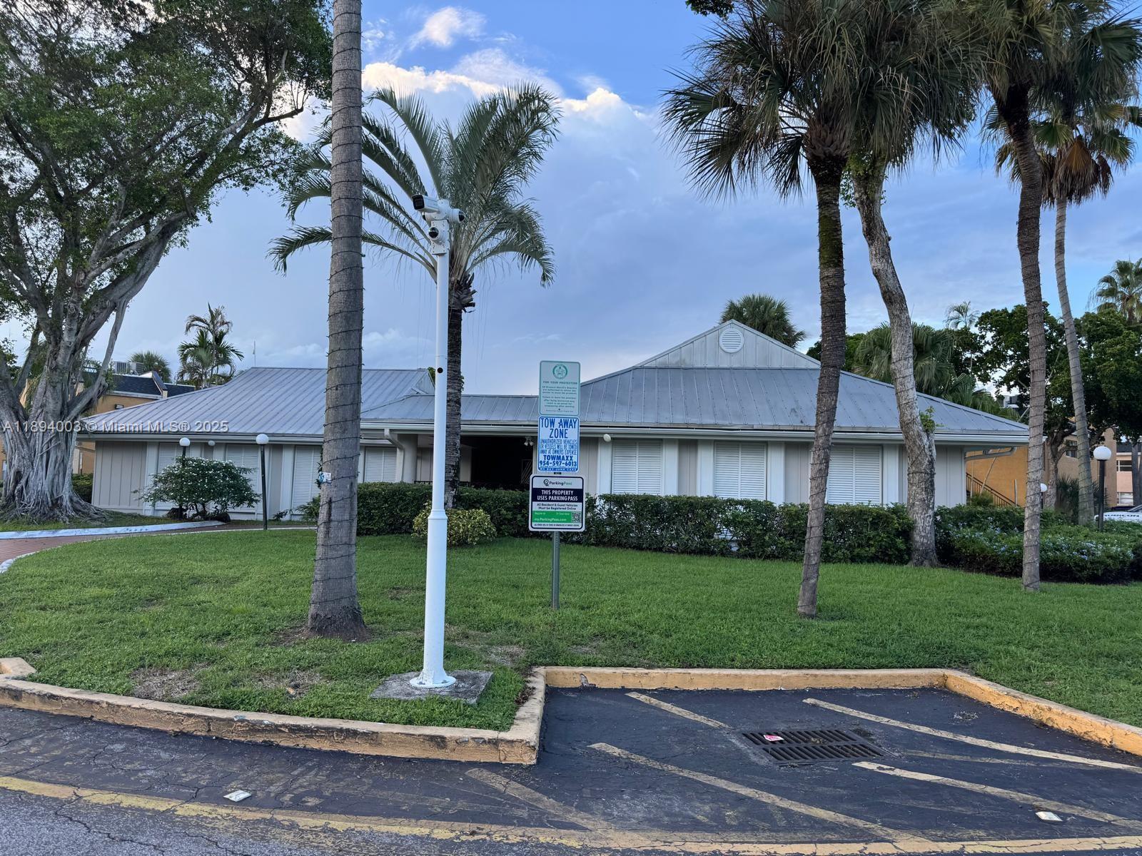 4453 Treehouse Lane, Unit C Tamarac, FL 33319 - Photo 21 of 21 a view of a white house with a big yard and palm trees