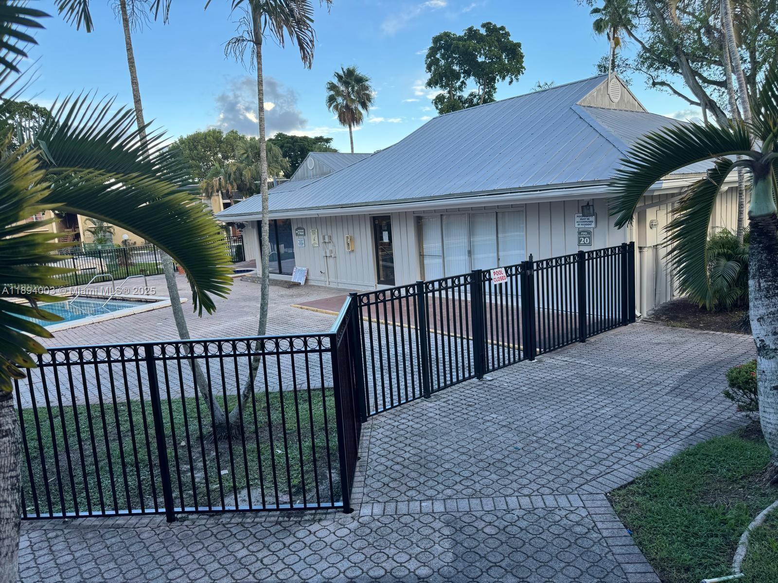 4453 Treehouse Lane, Unit C Tamarac, FL 33319 - Photo 4 of 21 a front view of a house with a garden