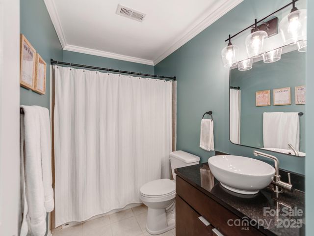 a white toilet sitting next to a bathroom sink and a mirror