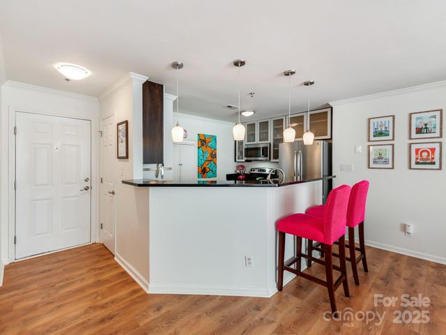 a kitchen with a refrigerator a dining table and chairs
