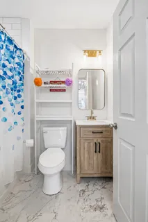 a bathroom with a toilet sink and mirror