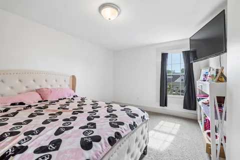 a bedroom with a bed and a flat screen tv