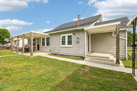 a view of a house with backyard and sitting area