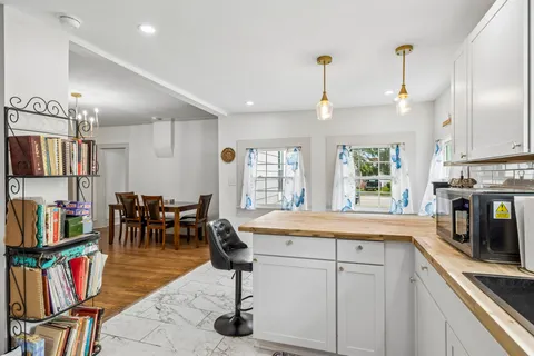 a kitchen with stainless steel appliances granite countertop a sink a stove and a wooden floors