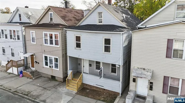 a front view of a house with a tree