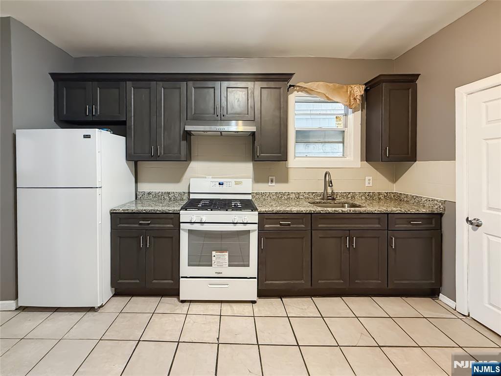 339 Howe Avenue, Unit 1 Passaic, NJ 07055 - Photo 3 of 23 a kitchen with a refrigerator and a stove