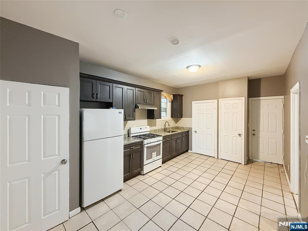 339 Howe Avenue, Unit 1 Passaic, NJ 07055 - Photo 4 of 23 a kitchen with a refrigerator a stove top oven and cabinets
