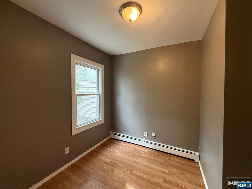 339 Howe Avenue, Unit 1 Passaic, NJ 07055 - Photo 8 of 23 an empty room with wooden floor and windows