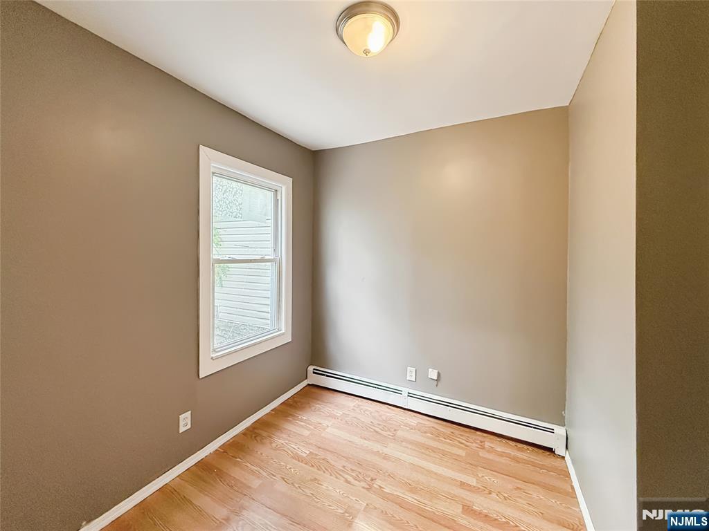 339 Howe Avenue, Unit 1 Passaic, NJ 07055 - Photo 9 of 23 a view of an empty room with wooden floor and a window